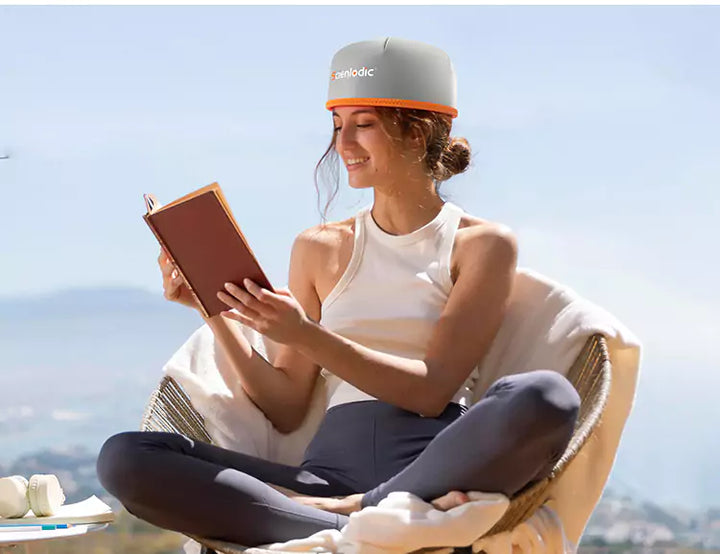 A woman reading relaxes using SciVive Hair+ Classic