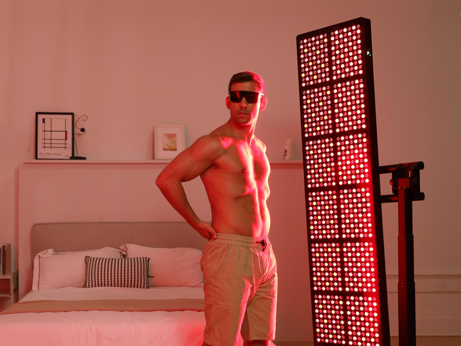 a man do yoga under full body red light therapy panel