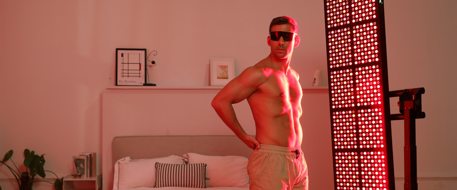 a man do yoga under full body red light therapy panel